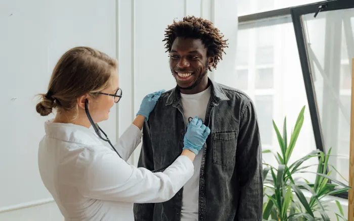 doctor using stethoscope on patient
