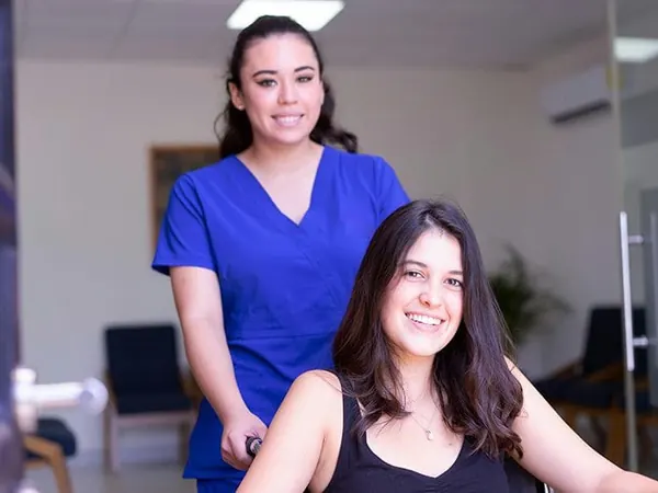 nurse standing behind patient in wheelchair